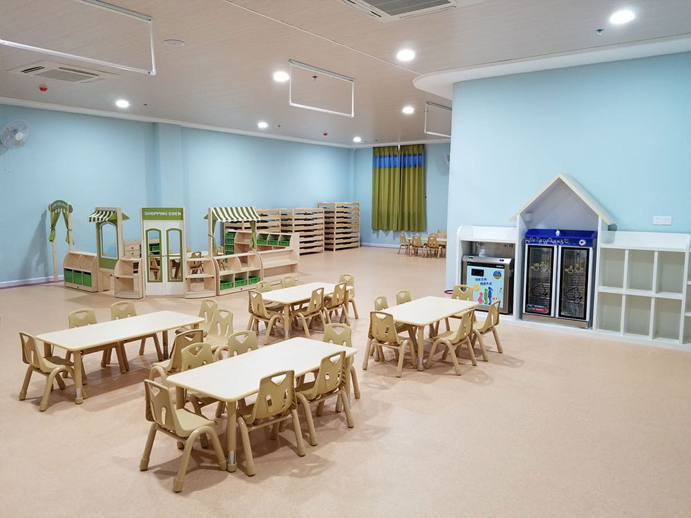 幼儿园公共活动区域内涂黄色调的塑胶地板和天蓝色的墙体浑然一体形成